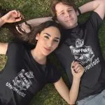 Schwarzes T-Shirt mit einem weißen Anker-Motiv, das von einem Banner mit dem Wort „Perfekt“ umschlungen wird, darunter steht in verspielter Schrift „Unperfekt“.