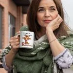 Weiße Kaffeetasse mit einer Illustration einer wütenden Giraffe mit verschränkten Armen und dem lustigen Spruch „Ich guck wie ich will – das nennt man Fressefreiheit“.