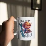 Weiße Kaffeetasse mit einer Illustration eines mürrischen Hochlandrinds im Karohemd und dem Wortspiel-Schriftzug „Das ist ja YAKtastisch“.